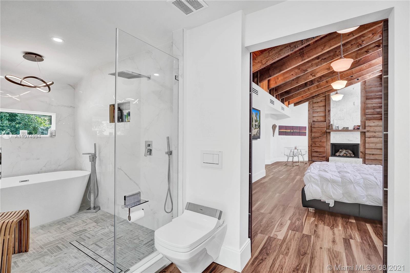 3570 Main Highway Miami, FL 33133 - Photo 38 of 76 a spacious bedroom with a bed and a wooden floor