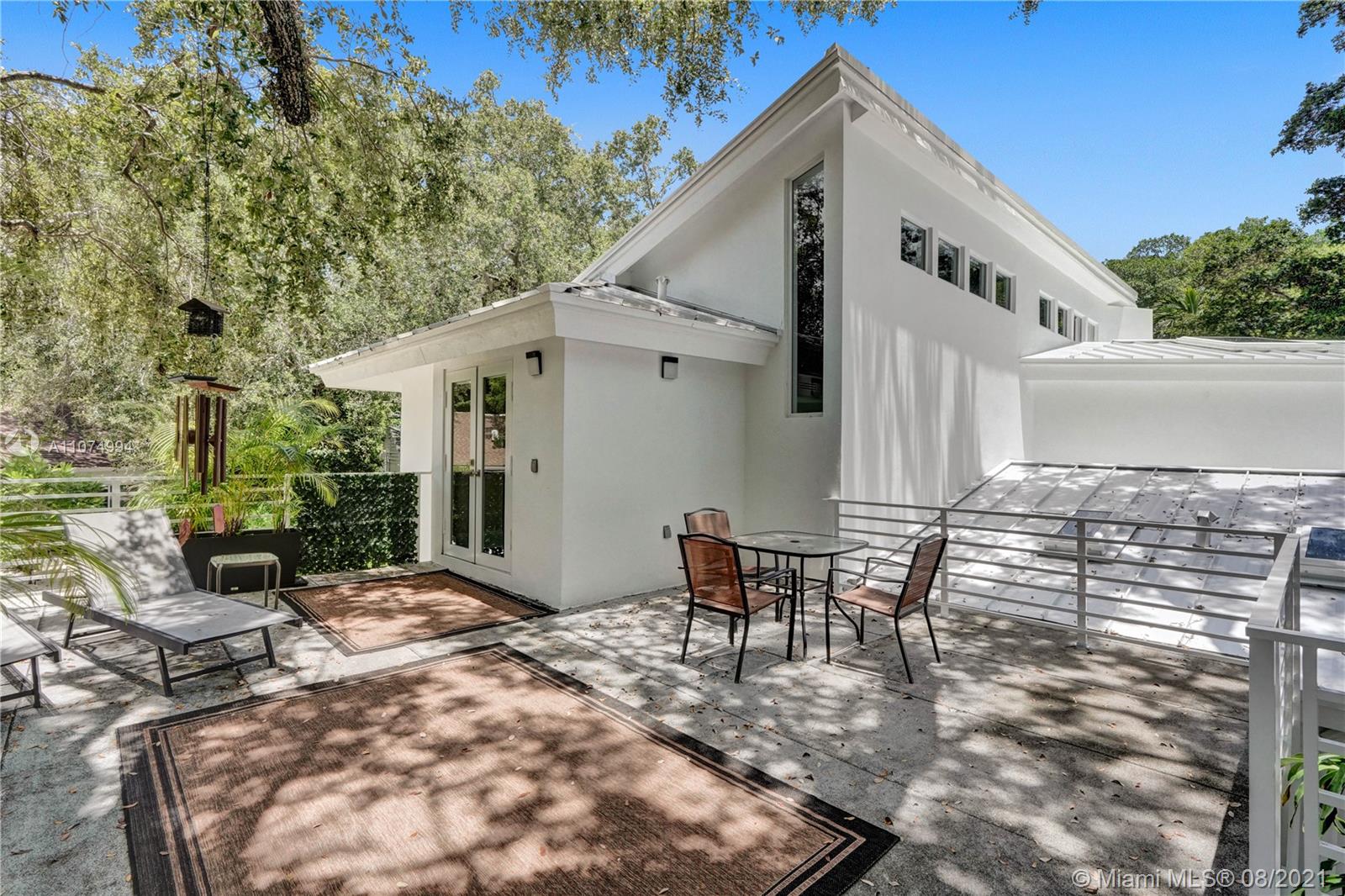 3570 Main Highway Miami, FL 33133 - Photo 41 of 76 a view of a patio with table and chairs with wooden floor and fence