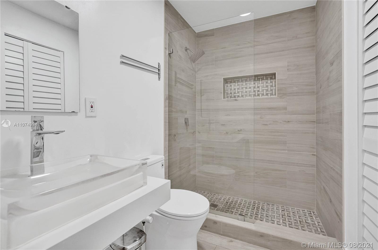 3570 Main Highway Miami, FL 33133 - Photo 42 of 76 a bathroom with a sink a toilet and shower