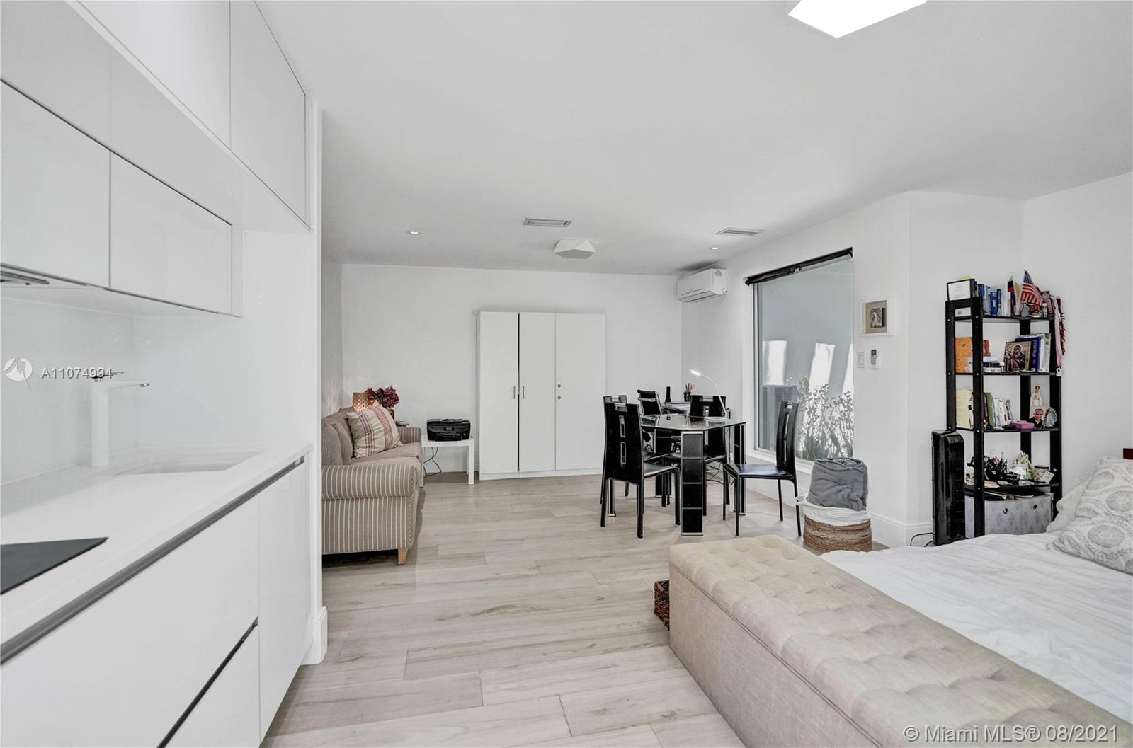 3570 Main Highway Miami, FL 33133 - Photo 58 of 76 a living room with furniture and a kitchen view