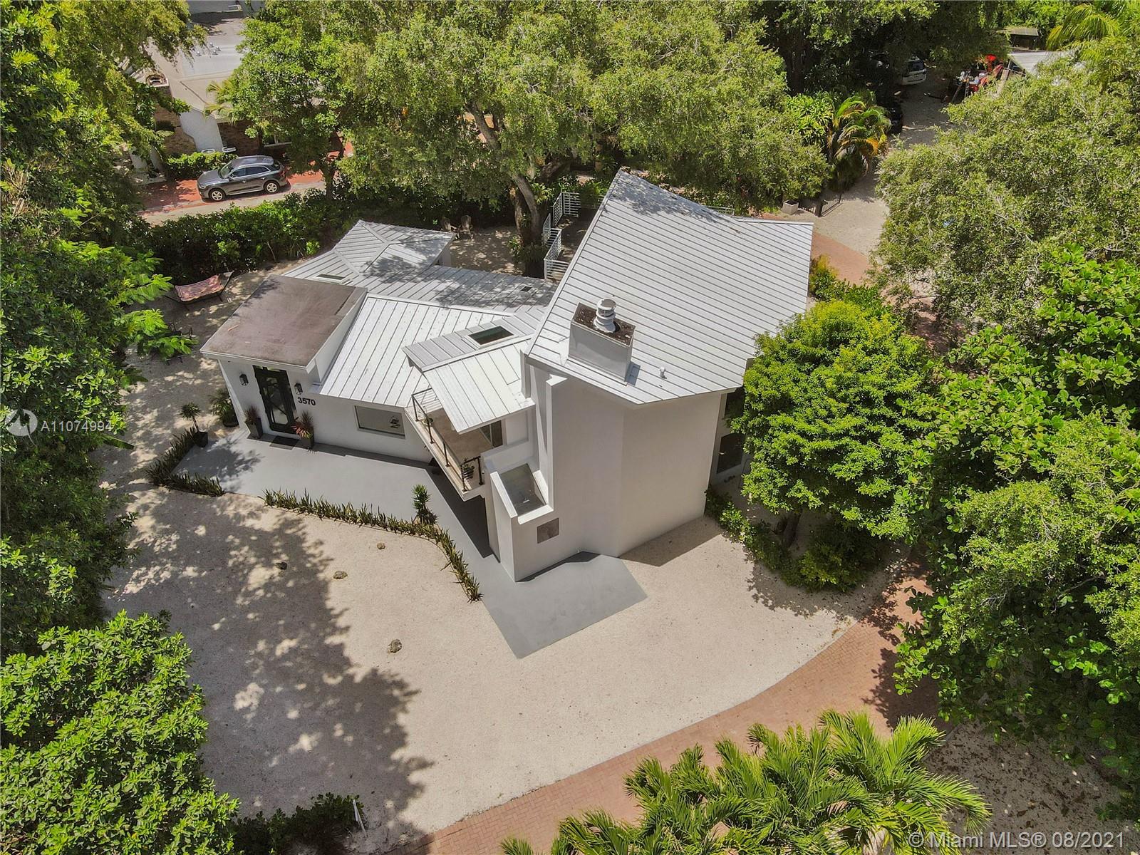 3570 Main Highway Miami, FL 33133 - Photo 75 of 76 an aerial view of a house with a yard and covered with trees