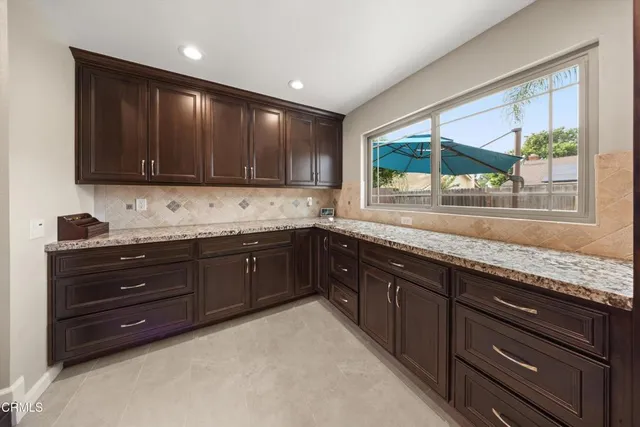 a kitchen with granite countertop wooden cabinets and a stove top oven