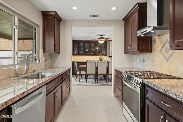 a kitchen with stainless steel appliances granite countertop a sink stove and cabinets