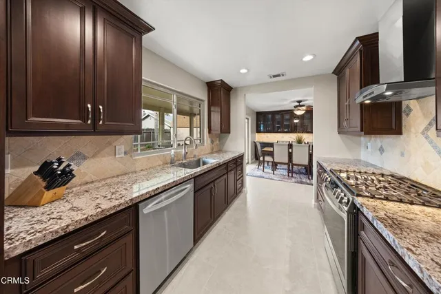 a large kitchen with stainless steel appliances granite countertop a stove a sink and a microwave