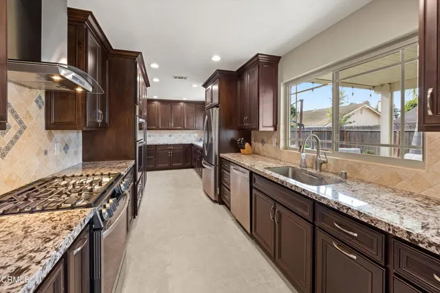 a kitchen with stainless steel appliances granite countertop a stove and a sink