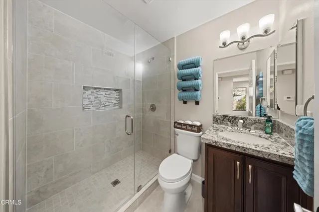 a bathroom with a granite countertop sink toilet and shower