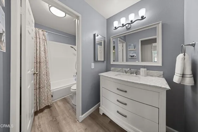 a bathroom with a granite countertop sink mirror and a shower