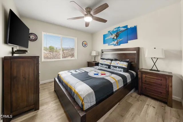 a bedroom with a bed and a flat tv screen on dresser