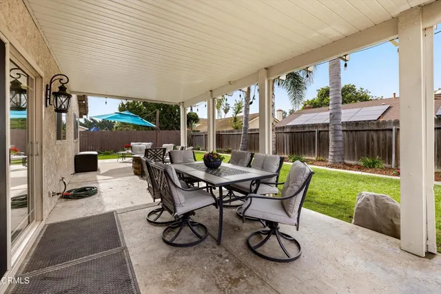 a view of a patio with a table chairs and a yard