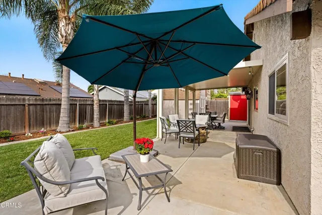 a view of a patio with a table and chairs under an umbrella
