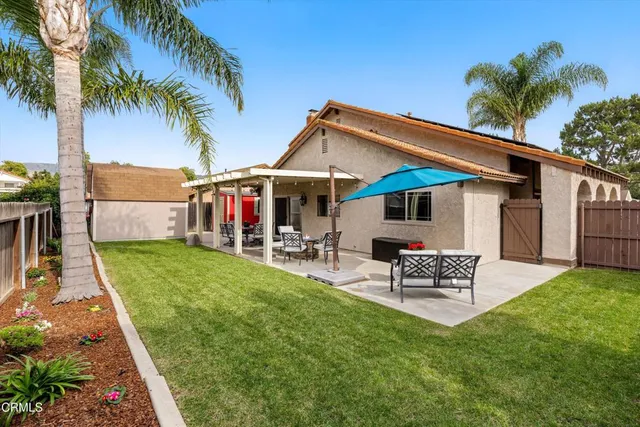 a view of a house with a yard and patio