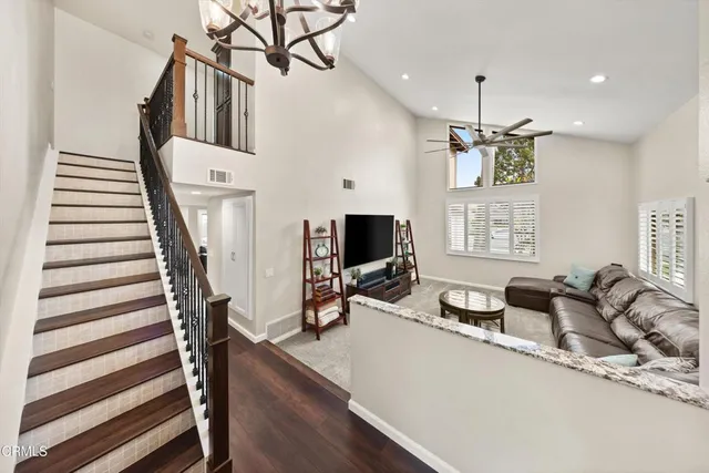 a living room with furniture a flat screen tv and a wooden floor