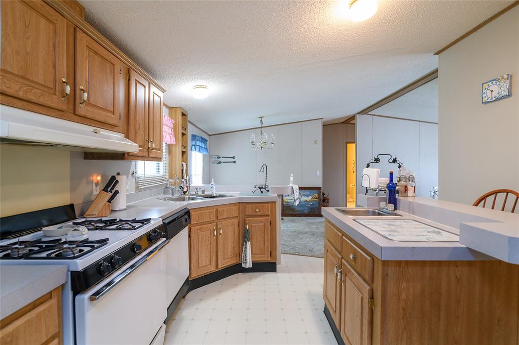 122 Grice Road Ringgold, LA 71068 - Photo 6 of 26 Kitchen featuring wood-finish cabinetry, white appliances, and light-toned countertops