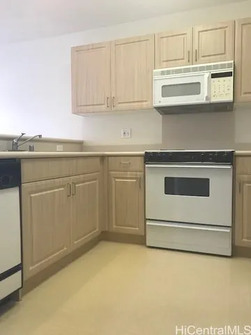 a kitchen with stainless steel appliances granite countertop a stove and white cabinets