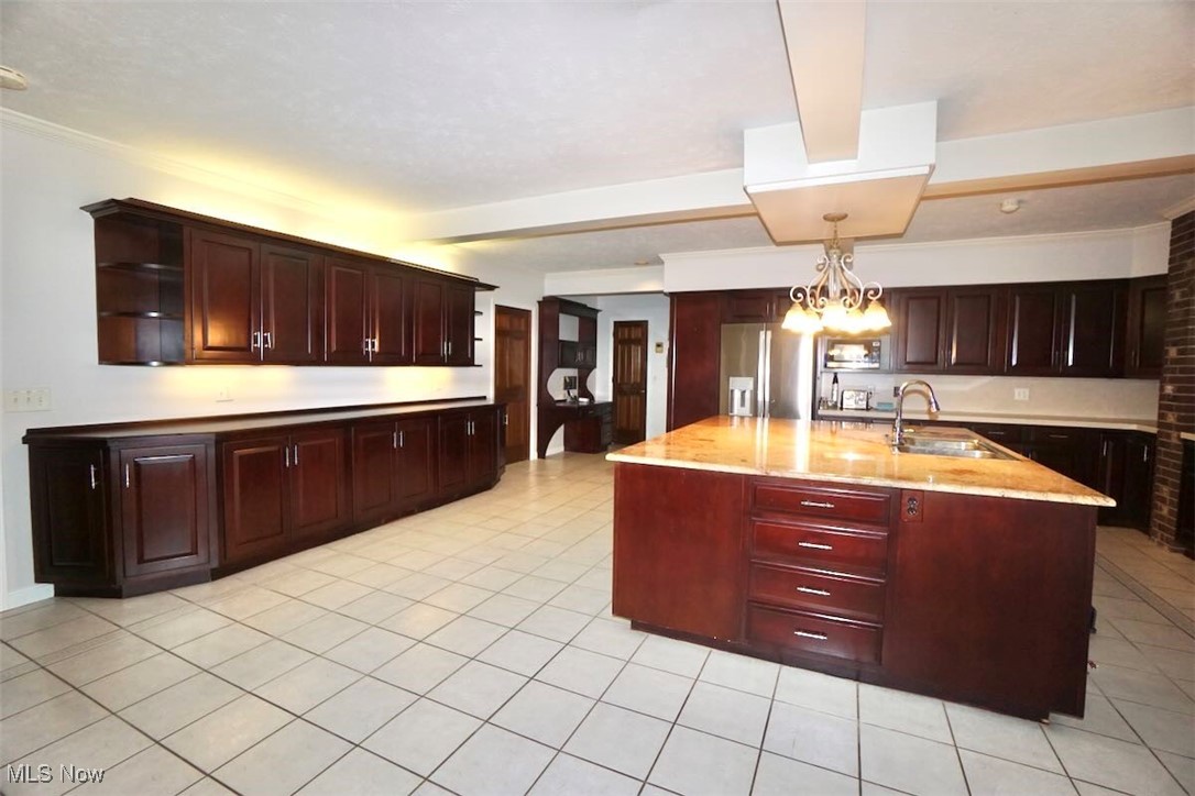 1760 Chartley Road Gates Mills, OH 44040 - Photo 10 of 49 Kitchen featuring a huge island with sink, appliances with stainless steel finishes, light tile patterned floors, and a chandelier