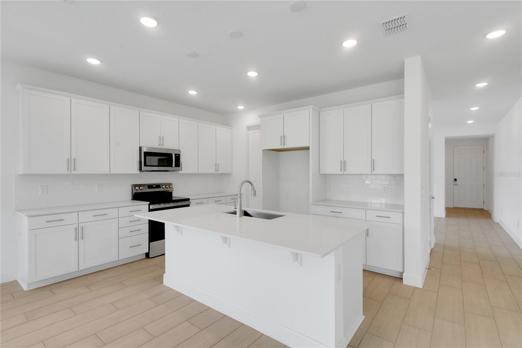 3723 Malad Way Tavares, FL 32778 - Photo 6 of 24 a kitchen with stainless steel appliances a sink stove and refrigerator