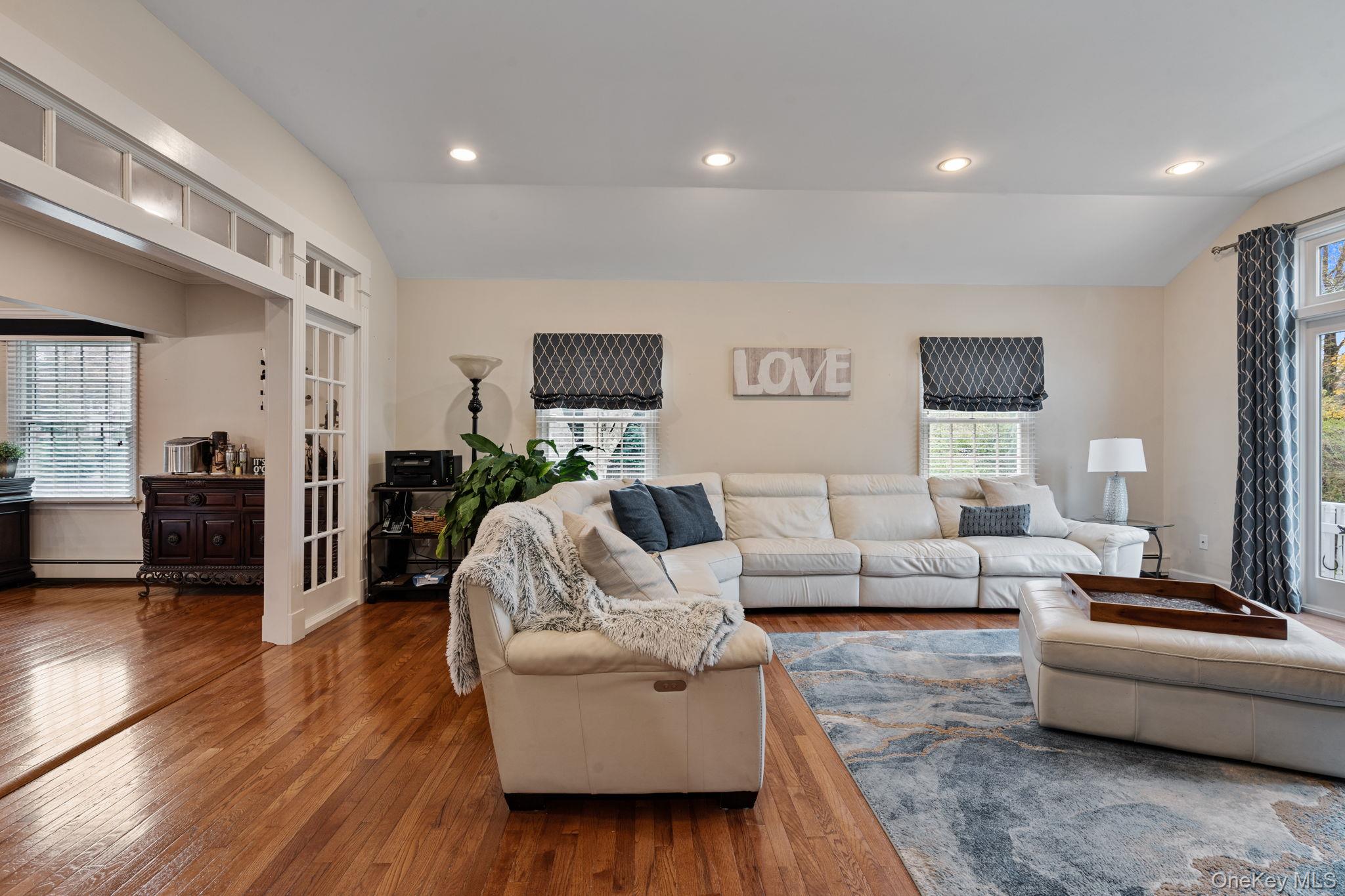 6 Daniel Way Setauket, NY 11733 - Photo 21 of 41 Living room featuring vaulted ceiling, healthy amount of natural light, hardwood / wood-style flooring, recessed lighting, and baseboard heating