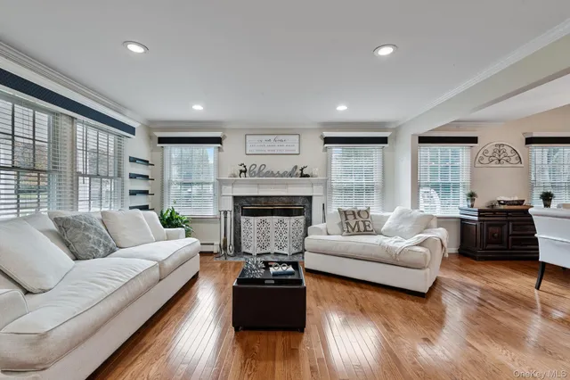 a living room with furniture kitchen view and a wooden floor