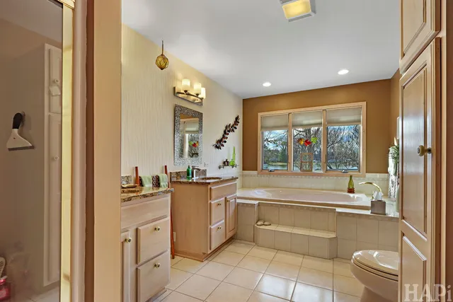 a spacious bathroom with a granite countertop sink toilet and shower