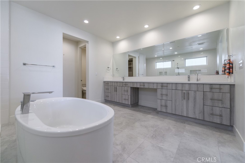 59 Dorado Irvine, CA 92618 - Photo 42 of 66 a large bathroom with a double vanity sink a large mirror and a bathtub