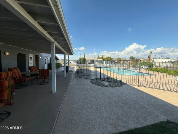 a view of a patio with table and chairs next to an umbrella