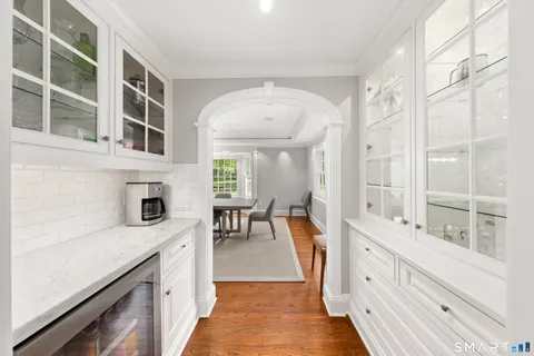 a very nice looking kitchen with granite countertop a stove and a white cabinets