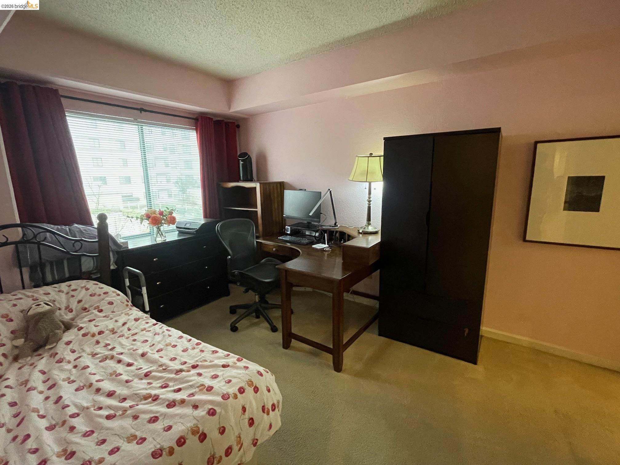 989 Webster Street, Unit 450 Oakland, CA 94607 - Photo 11 of 16 a bedroom with a bed computer sitting on desk and a chair