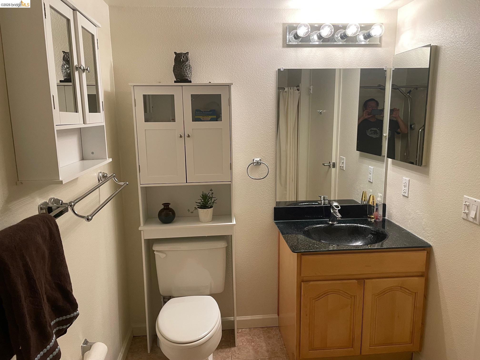 989 Webster Street, Unit 450 Oakland, CA 94607 - Photo 7 of 16 a bathroom with a toilet a sink and mirror