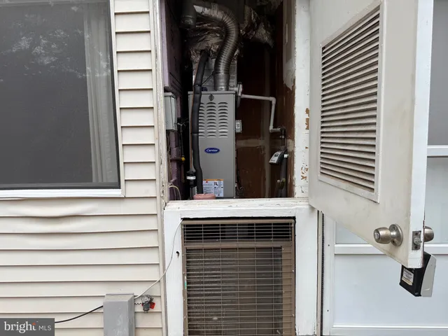 a view of house next to a yard with large tree