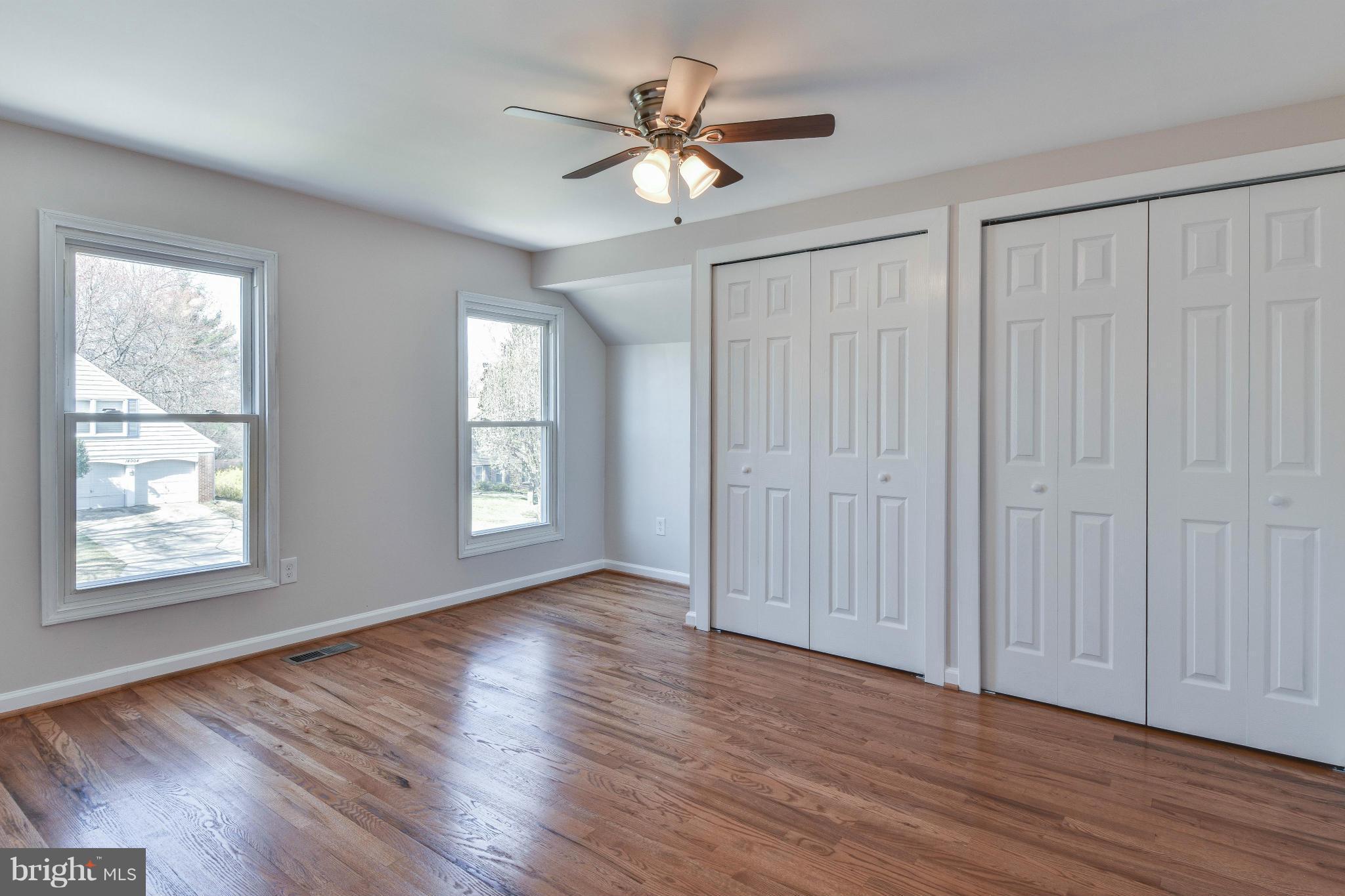 14001 Pond View Road Silver Spring, MD 20905 - Photo 20 of 30 an empty room with wooden floor chandelier fan and windows