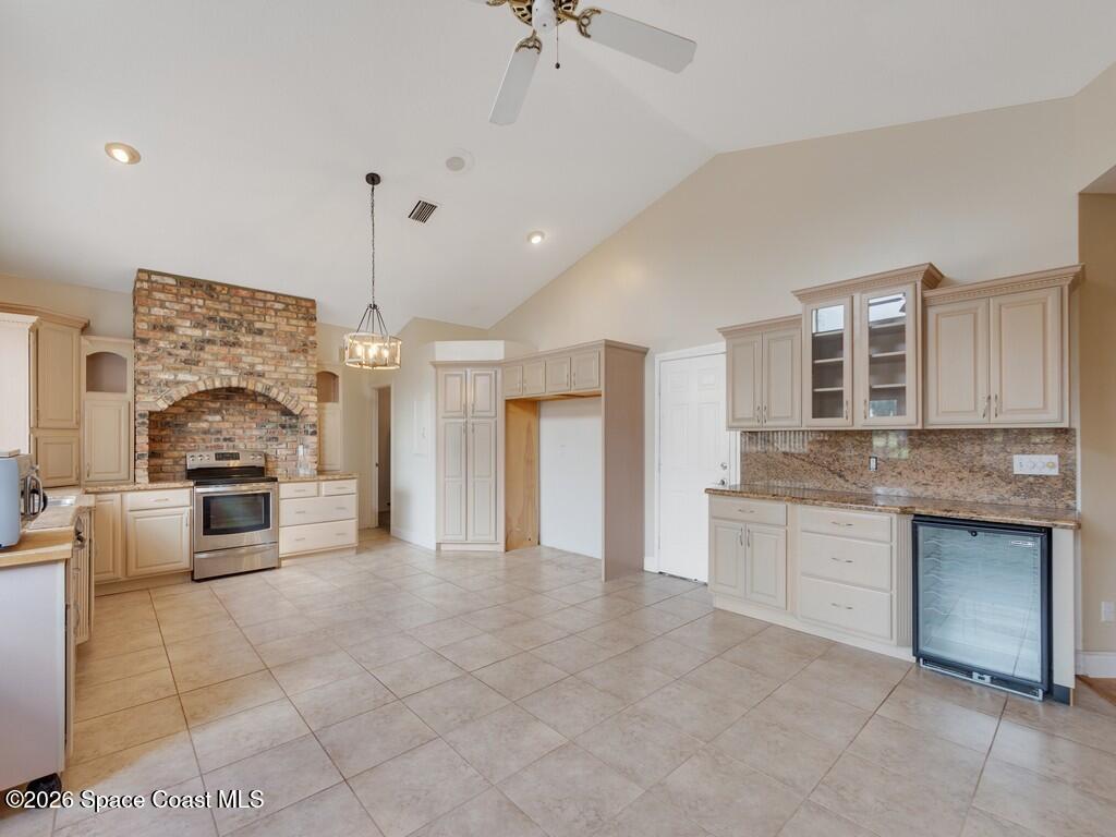 167 Deer Run Road Palm Bay, FL 32909 - Photo 13 of 36 a large kitchen with granite countertop a stove a sink a counter space and cabinets