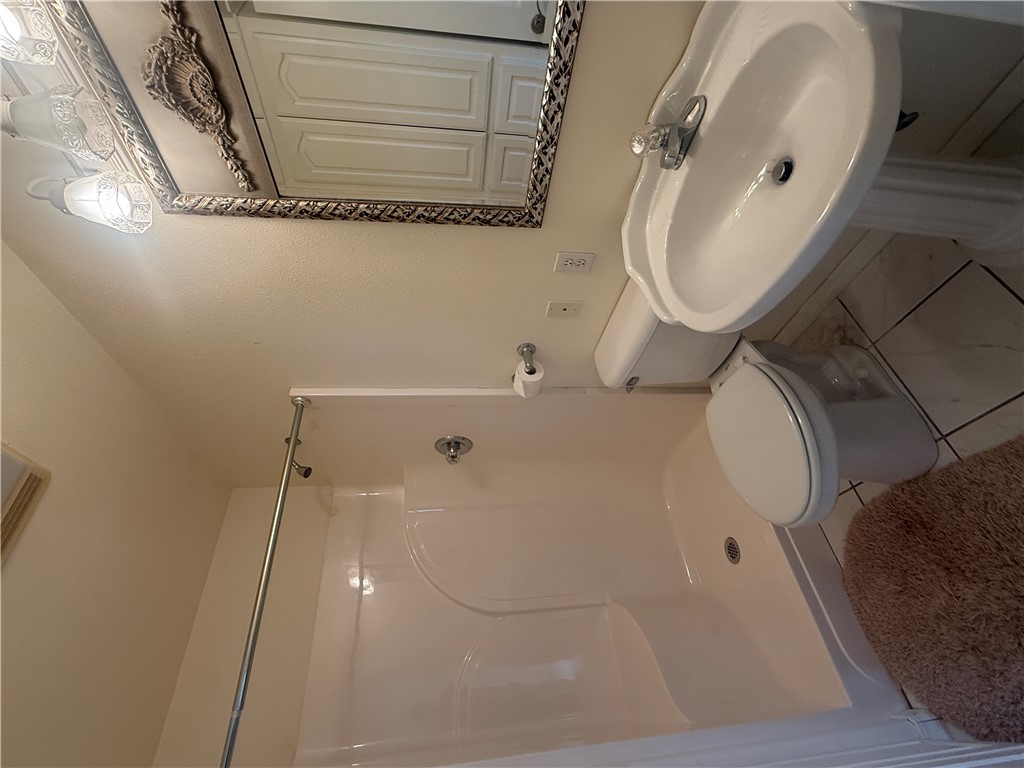684 Private 2479 Road Clarksville, AR 72830 - Photo 15 of 25 Bathroom featuring a white pedestal sink, a toilet, a walk-in shower with a chrome showerhead, and a decorative framed mirror