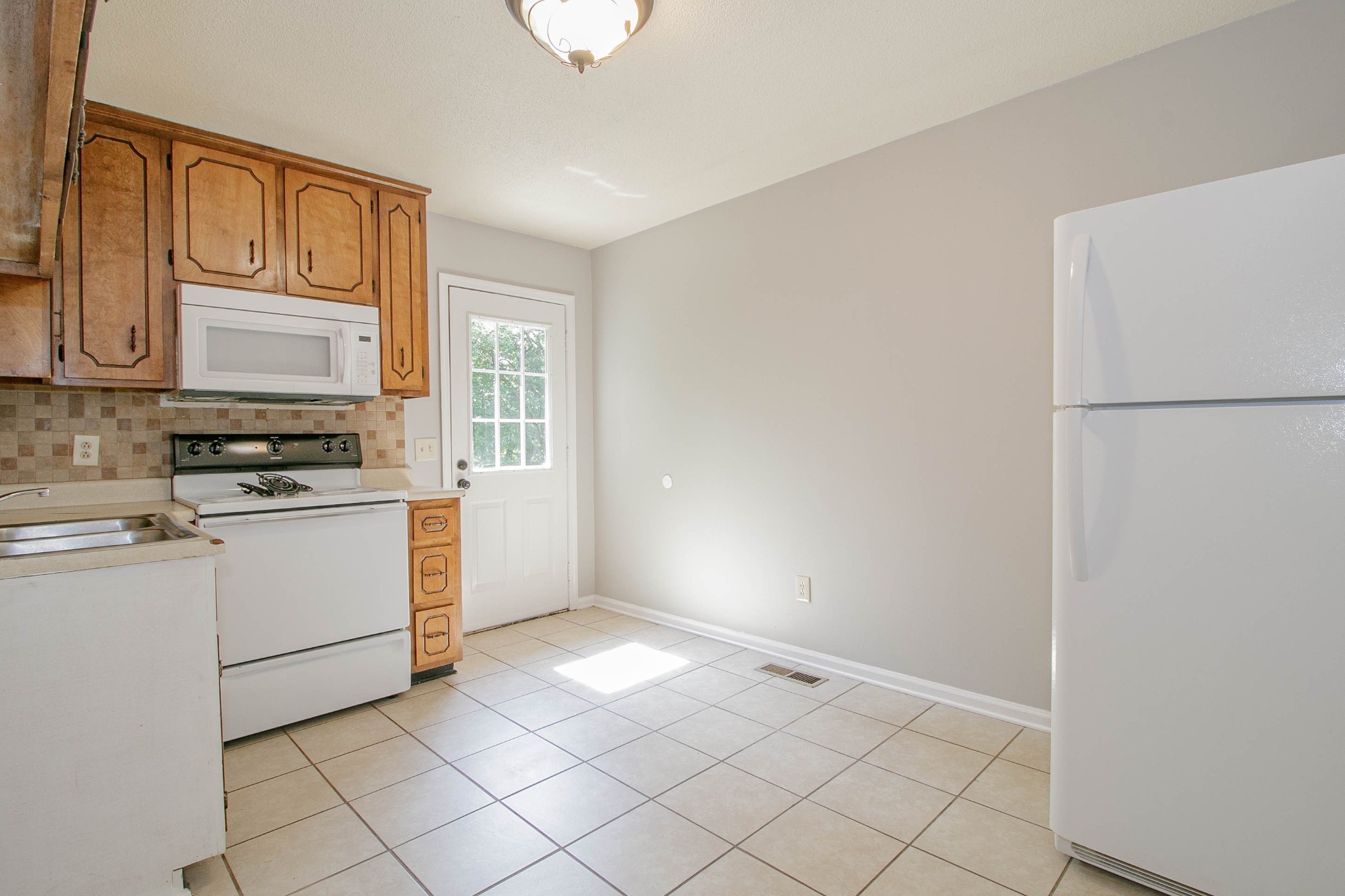 1088 Mcdaniel Road Clarksville, TN 37043 - Photo 26 of 71 a kitchen with a stove a sink and a refrigerator
