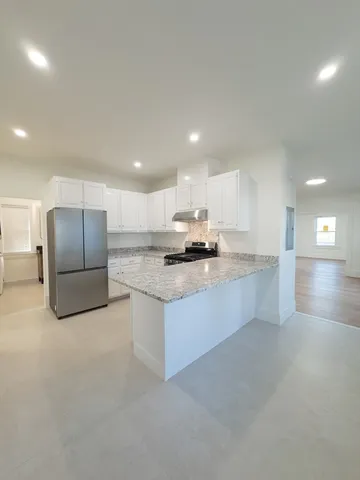 a bathroom with a granite countertop sink a toilet and mirror