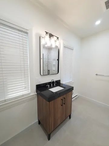 a bathroom with a granite countertop toilet a sink and shower
