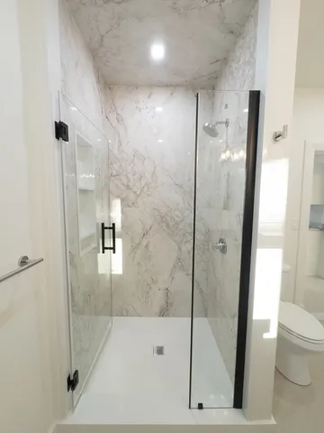a bathroom with a shower a toilet and a sink