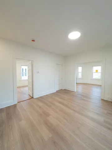 a view of empty room with kitchen and window