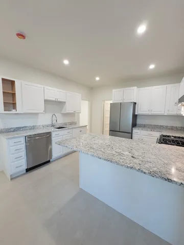 a kitchen with cabinets appliances a sink and a window