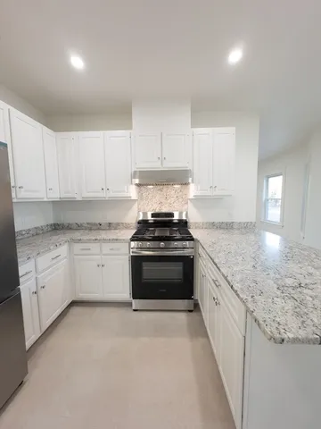 a stove top oven sitting inside of a kitchen