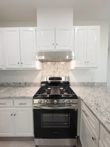 a kitchen with granite countertop a stove and a sink
