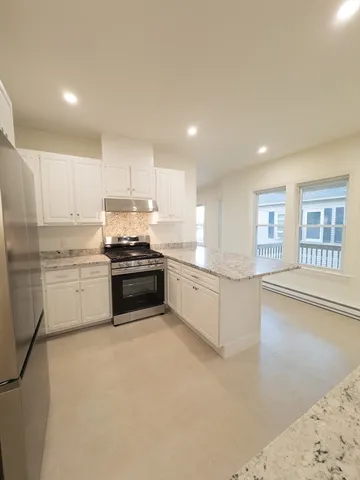 a kitchen with stainless steel appliances granite countertop a sink and a refrigerator