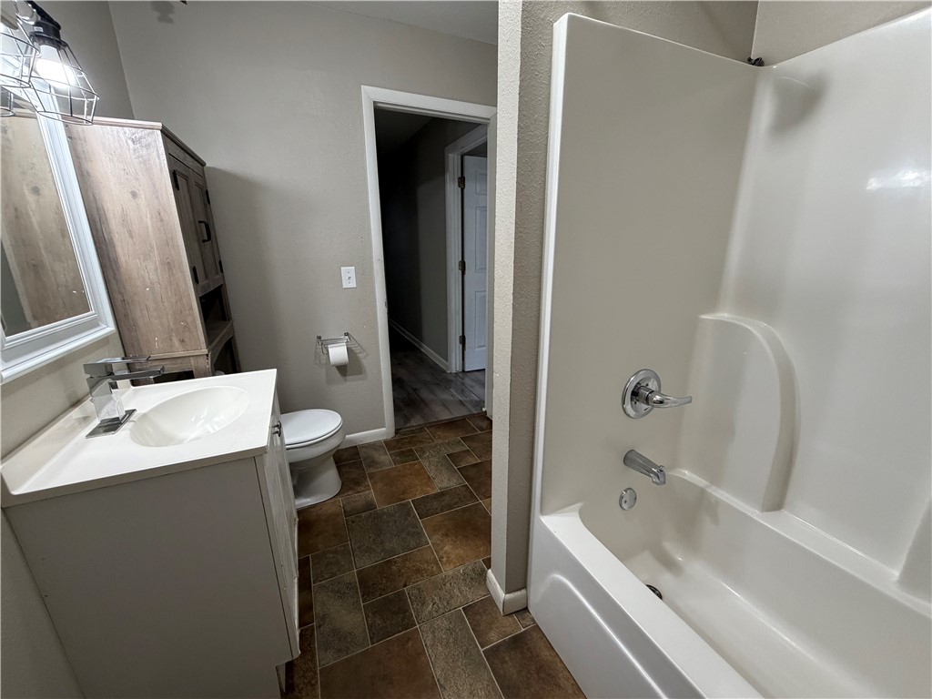 909 Riddell Street Clarksville, AR 72830 - Photo 15 of 26 Bathroom featuring a white vanity with a rectangular sink, chrome faucet, and mirrored cabinet