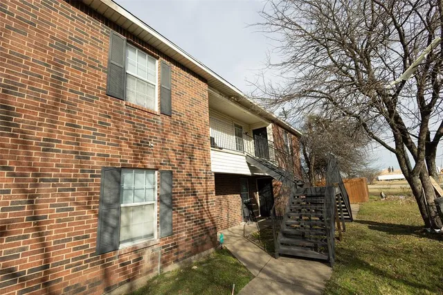 a front view of a house with large trees