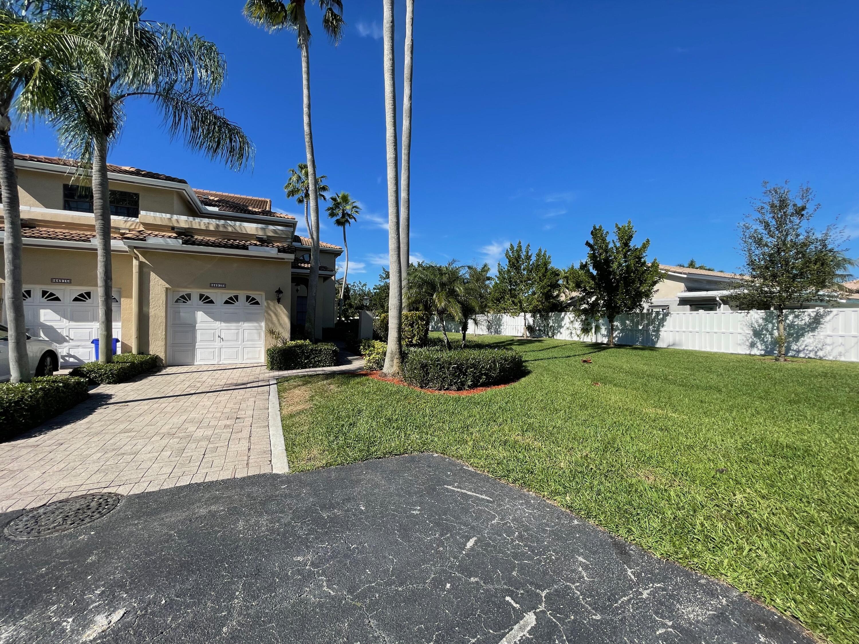 a view of a house with a yard and palm trees