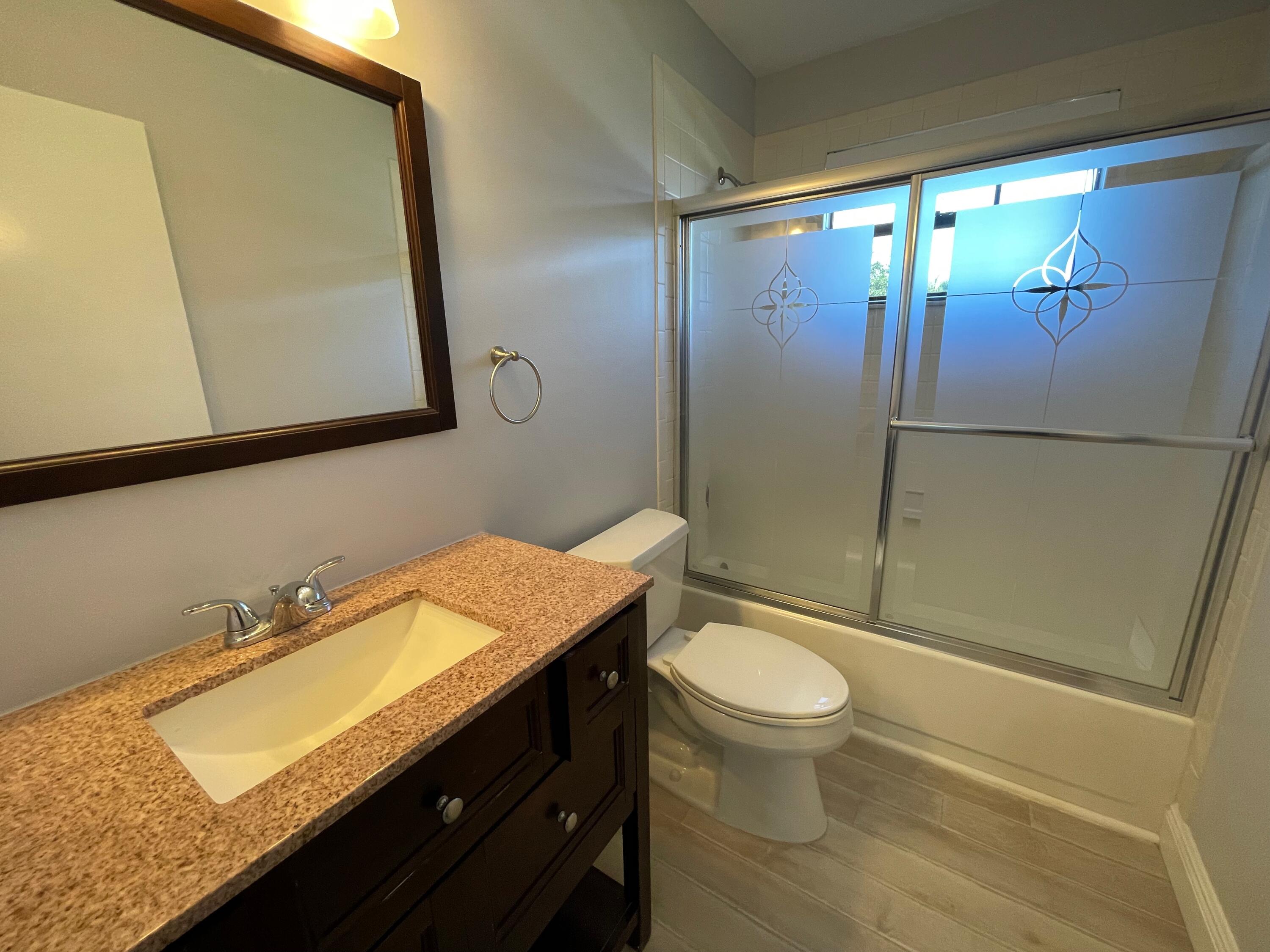 6691 Montego Bay Boulevard, Unit H Boca Raton, FL 33433 - Photo 12 of 22 a bathroom with a granite countertop sink toilet and shower
