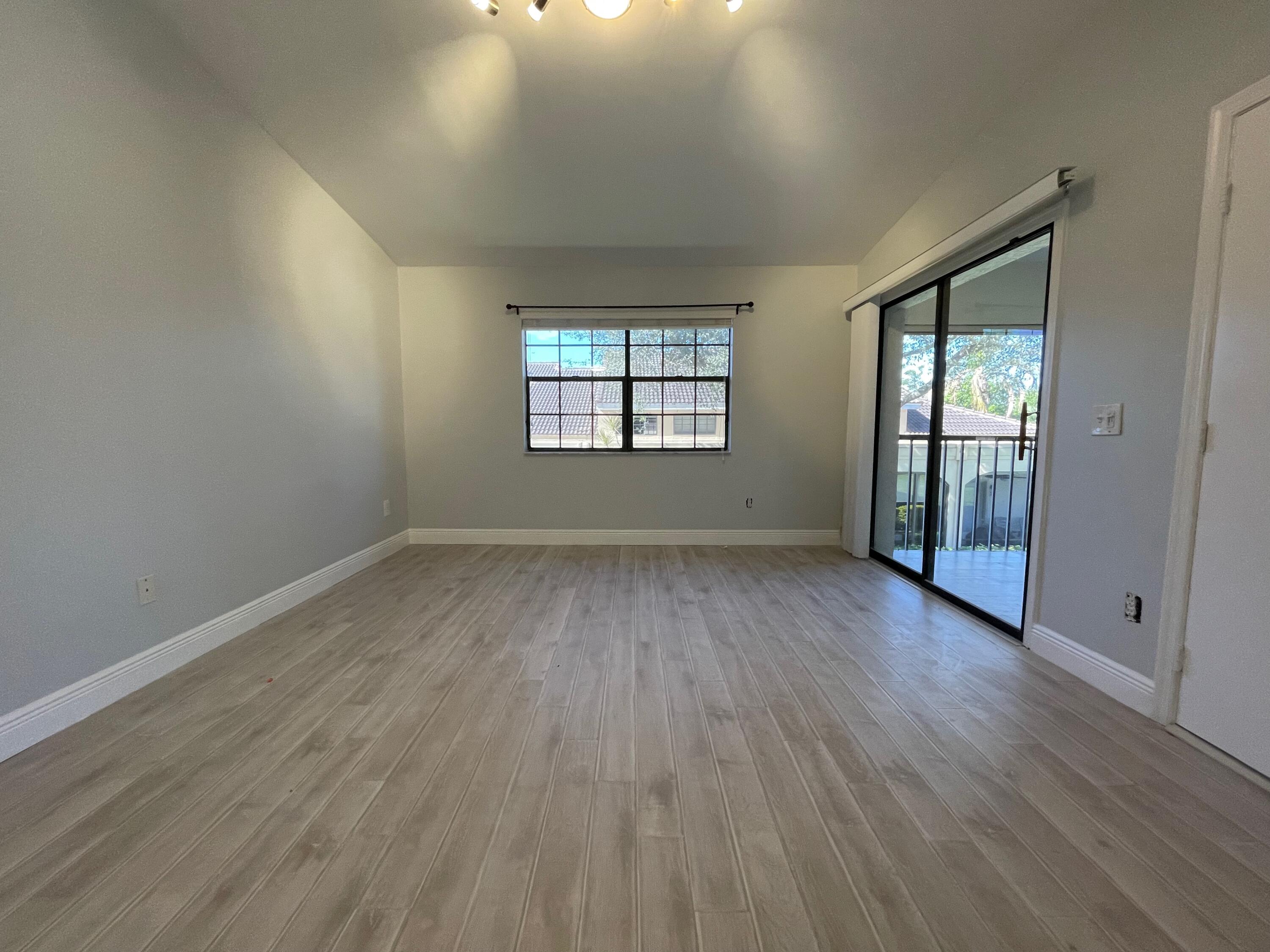 6691 Montego Bay Boulevard, Unit H Boca Raton, FL 33433 - Photo 15 of 22 an empty room with wooden floor and windows