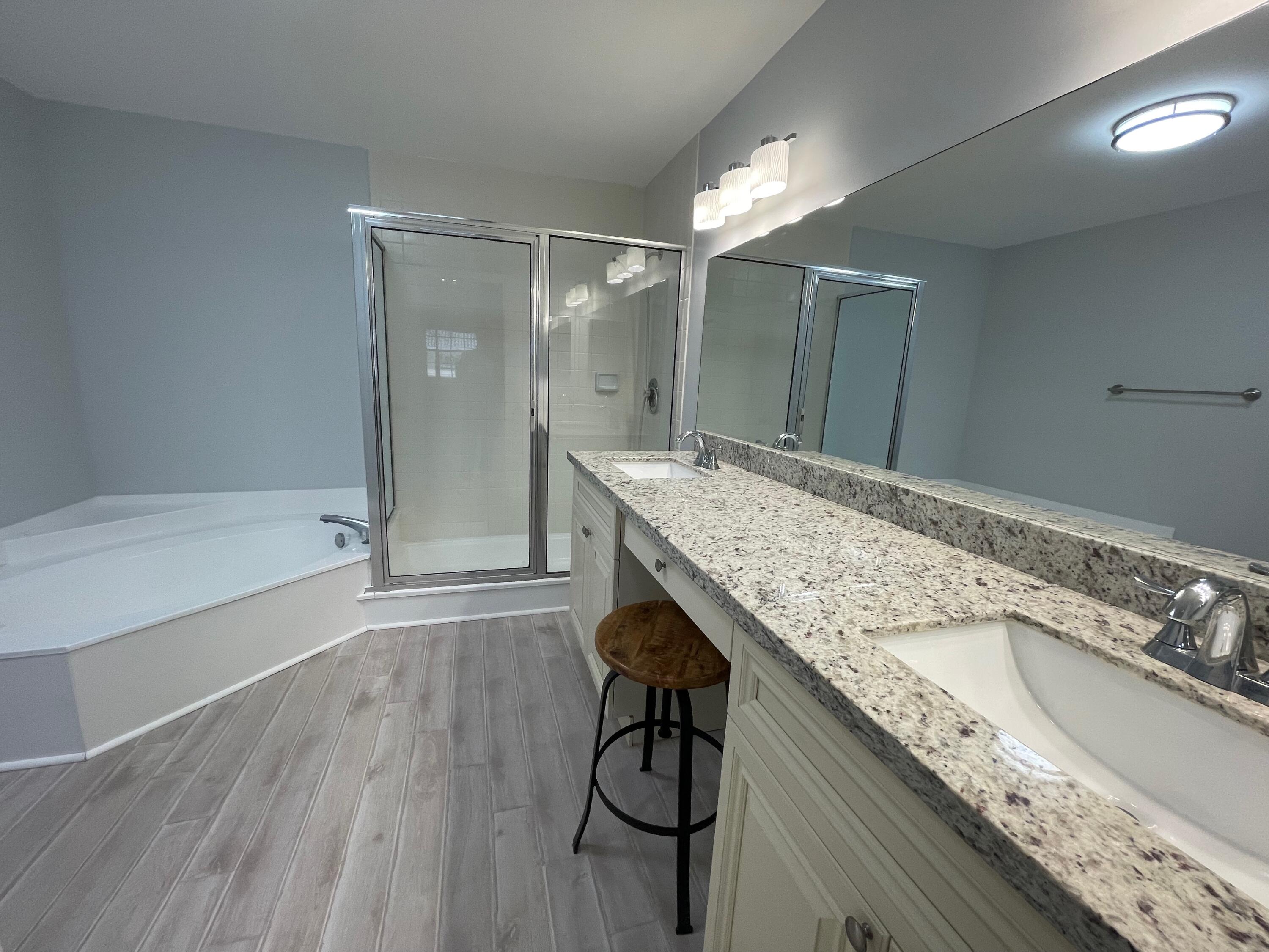 6691 Montego Bay Boulevard, Unit H Boca Raton, FL 33433 - Photo 16 of 22 a bathroom with a granite countertop sink a bathtub and shower