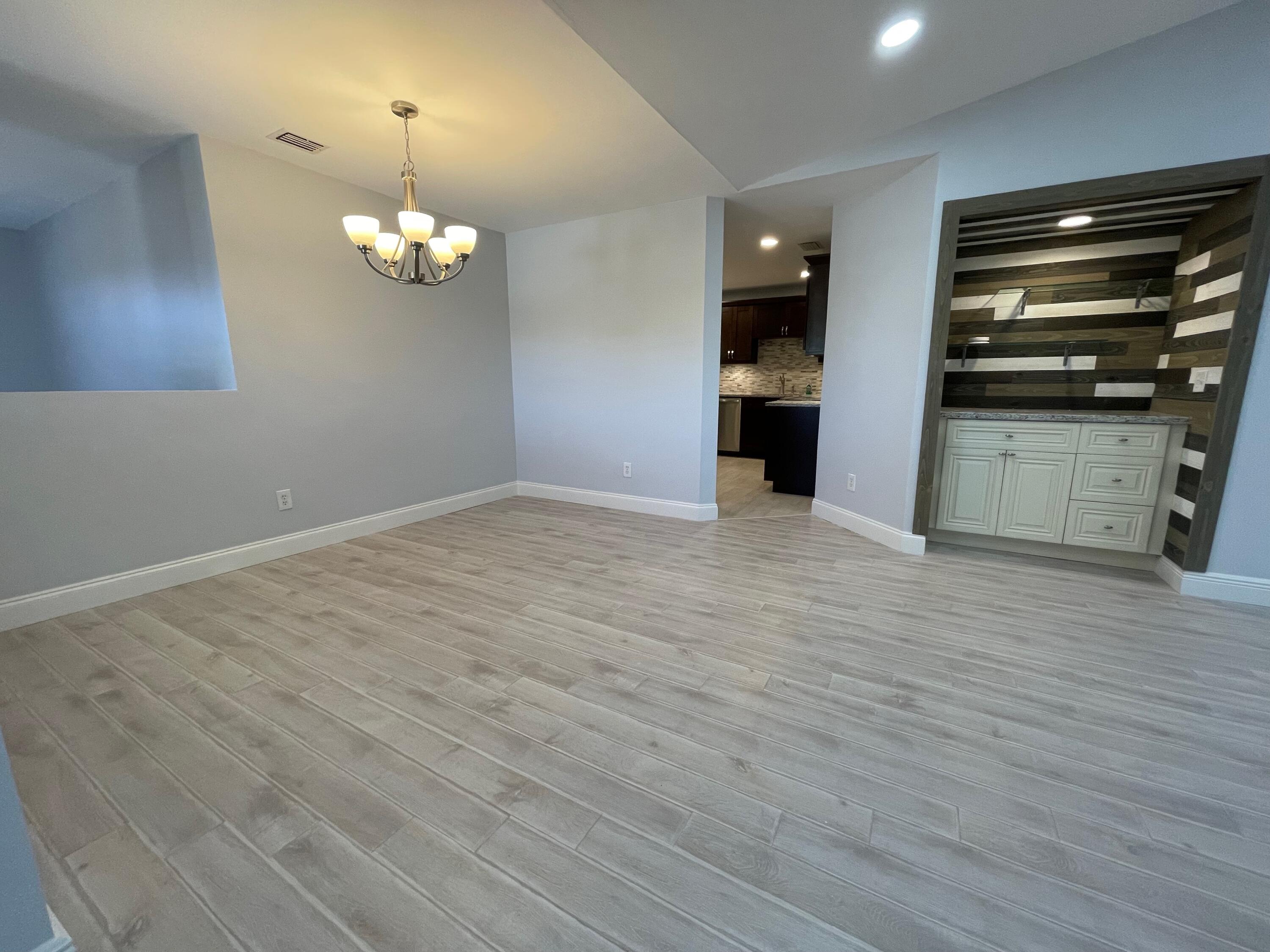 6691 Montego Bay Boulevard, Unit H Boca Raton, FL 33433 - Photo 4 of 22 wooden floor in an empty room with a kitchen