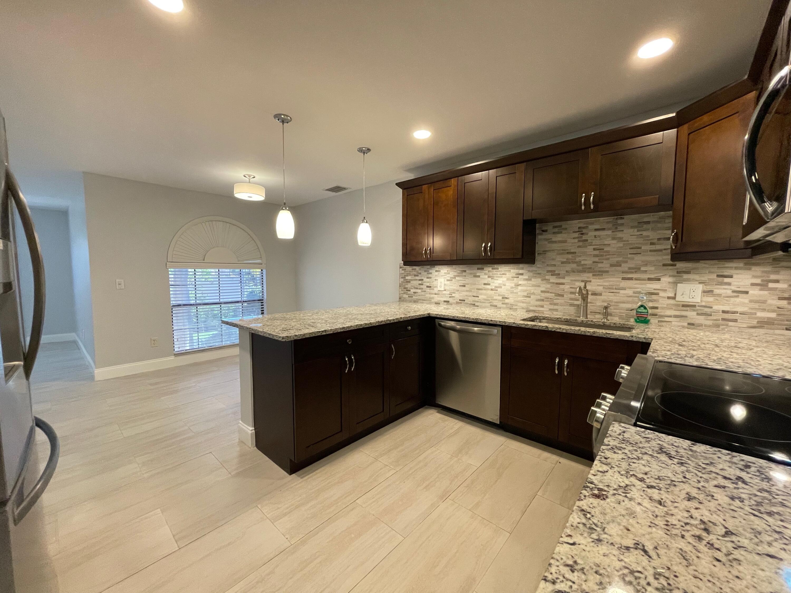 6691 Montego Bay Boulevard, Unit H Boca Raton, FL 33433 - Photo 5 of 22 a kitchen with a sink stove and cabinets
