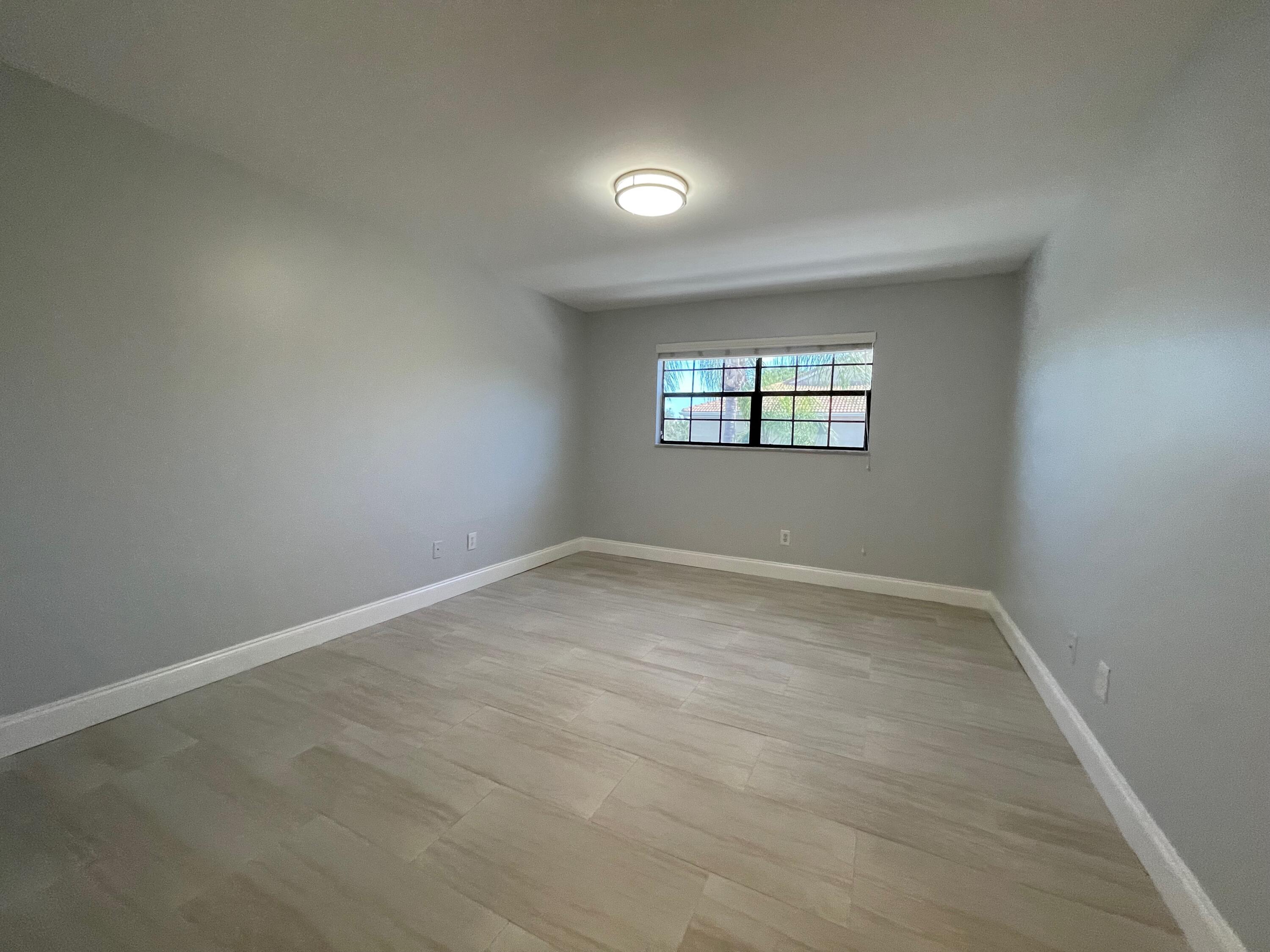 6691 Montego Bay Boulevard, Unit H Boca Raton, FL 33433 - Photo 8 of 22 an empty room with windows